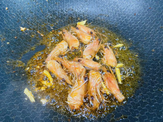 耳光炒饭,起油锅放入姜丝和虾头炒出虾油，然后取出虾头