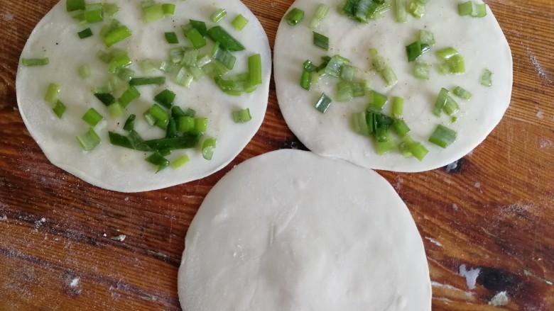 饺子皮葱油饼,两张面皮上抹上葱花和油。