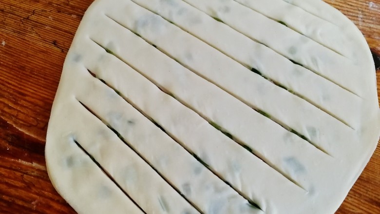 饺子皮葱油饼,擀成薄饼，中间划几刀。