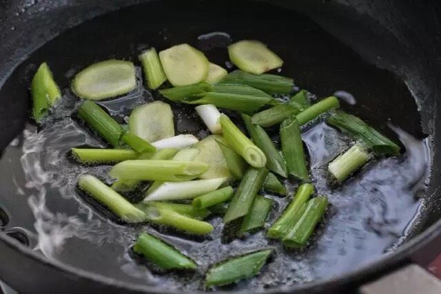 红烧鱼块,另起锅倒适量食用油烧至五成热，放入葱段和姜片小火炒香。