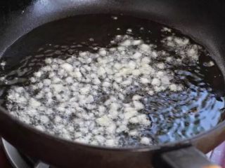 青椒土豆片,锅中倒适量食用油烧至五成热，放入一半的蒜末小火炒出香味。