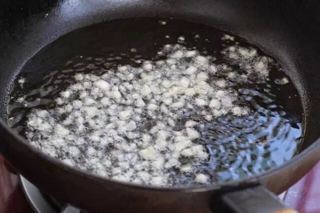 青椒土豆片,锅中倒适量食用油烧至五成热，放入一半的蒜末小火炒出香味。