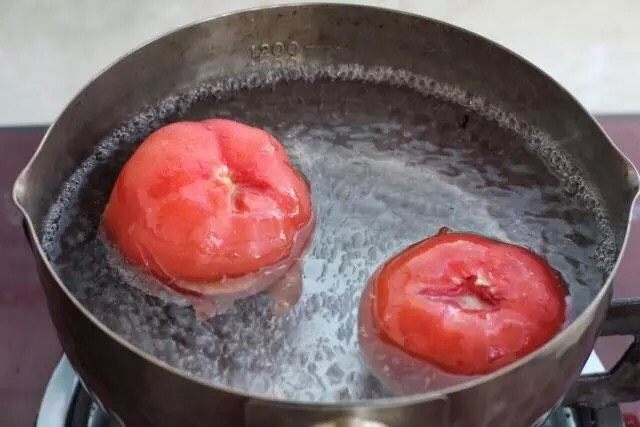 青椒土豆片,番茄去蒂在顶部划十字刀，锅中烧开水将十字位置朝下放入水中，烫煮二十秒左右捞出用凉水冲洗片刻。