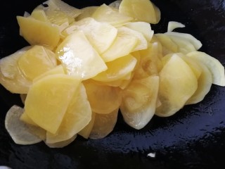 青椒土豆片,让每一片土豆片都包裹上油，文火翻炒一分钟。（水洗过的土豆片比较好熟）