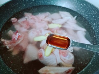 新疆大盘鸡,鸡块冷水下锅，加生姜片与料酒焯下水去腥。