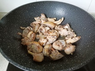 新疆大盘鸡,翻炒到鸡块表面微黄，炒出鸡肉当中的油脂，放适量姜蒜翻炒。