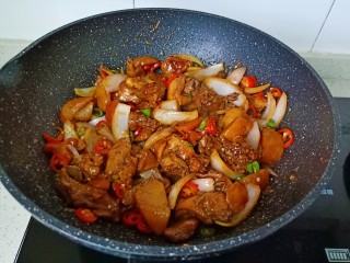 新疆大盘鸡,最后撒入青红椒翻炒至均匀即可出锅。
