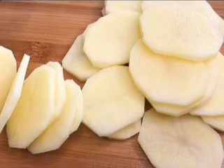 青椒土豆片,选两个大小适中的土豆，去皮，然后切成薄片。大一点的土豆呢，当然也可以，只是我不喜欢土豆被对半切了之后的样子，就是喜欢它完整的形状。
