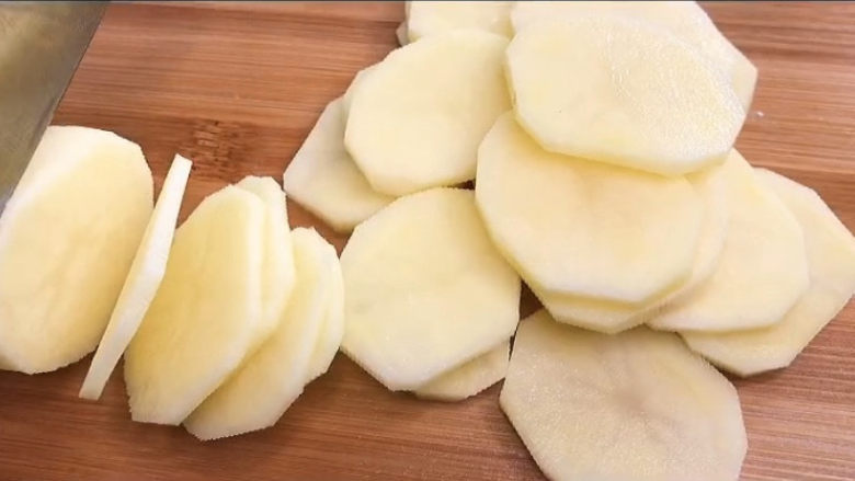 青椒土豆片,选两个大小适中的土豆，去皮，然后切成薄片。大一点的土豆呢，当然也可以，只是我不喜欢土豆被对半切了之后的样子，就是喜欢它完整的形状。
