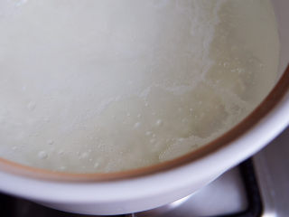 红薯南瓜粥,将米倒入煮开的水里。