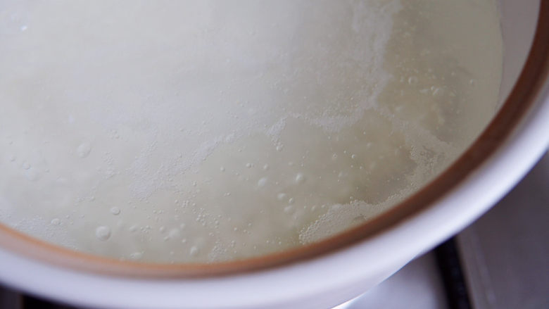 红薯南瓜粥,将米倒入煮开的水里。