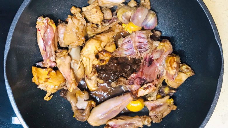 新疆大盘鸡,将鸡块扒拉到锅边，豆瓣酱放在锅中心，煸炒一下豆瓣酱