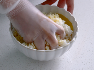 耳光炒饭,戴上手套将米饭和蛋液抓拌均匀，尽量保证每一粒米上都沾上蛋液