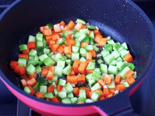 百吃不厌的蛋炒饭,另起油锅烧热，先爆香葱，再倒入黄瓜和胡萝卜。