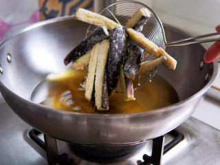 糖醋茄子,油温六七成热，中火，将茄条分次入锅炸制。