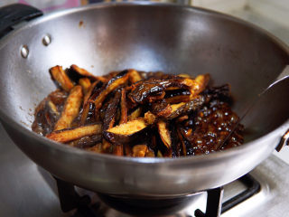 糖醋茄子,切条回锅，裹匀糖醋汁儿，关火，撒上香葱碎。