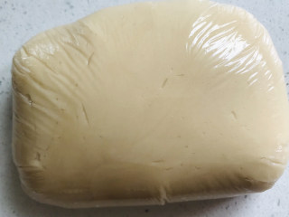 莲蓉蛋黄月饼,拌匀之后的月饼皮，用保鲜膜包起来，然后室温静置3小时左右。