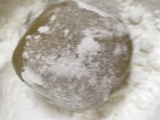 莲蓉蛋黄月饼,把月饼放入玉米淀粉中，薄薄滚上一圈，防止粘在模具上。