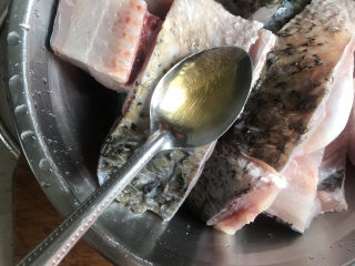 红烧鱼块,然后把鱼块放入盆中，鱼头用来炖汤，加入3勺料酒