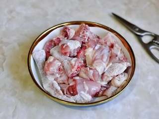 新疆大盘鸡,首先用食品剪刀将鸡剪小块，冷水冲洗干净。