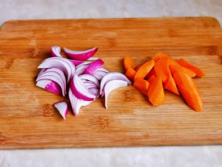 新疆大盘鸡,洋葱切条，胡萝卜去皮洗干净切菱形块。