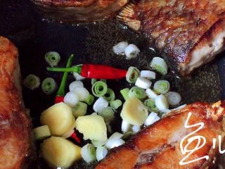 红烧鱼块,将鱼块扒到锅边，中间放入葱姜小米椒爆香