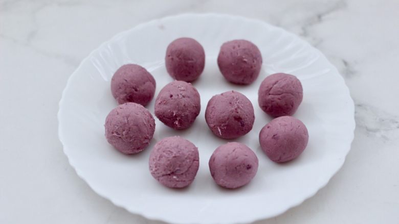 奶香紫薯芋泥华夫饼,把所有的食材混合搅拌均匀后，搓成等份的小圆球。