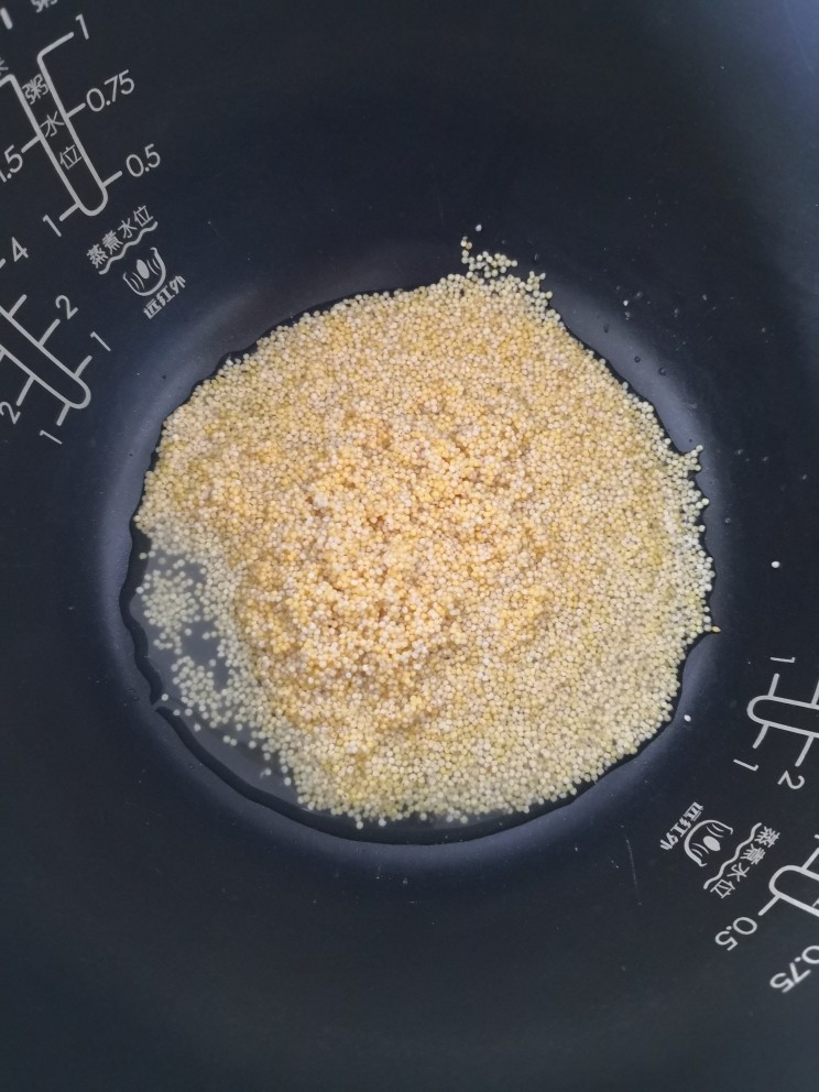 红薯南瓜粥,浸泡好的小米放入电饭锅里