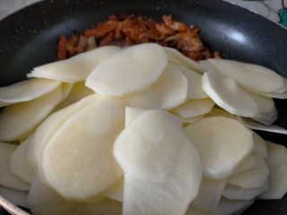 青椒土豆片,把肉推到锅一边，另一边倒入土豆片，把锅倾斜，炒肉的油会流出烹饪土豆