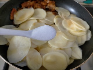 青椒土豆片,此时倒入适量盐在土豆片这边，翻炒均匀