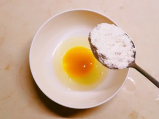 糖醋茄子,碗中敲入一个鸡蛋 放入面粉。