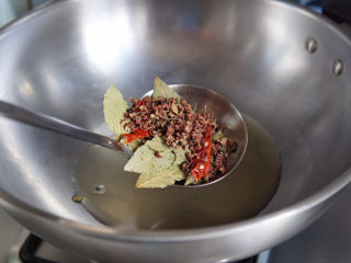 新疆大盘鸡,放入花椒、香叶、辣椒，小火慢慢煸炒出香味。