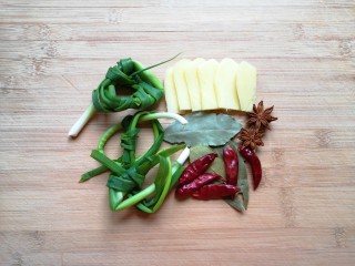 新疆大盘鸡,小葱打成结，生姜切成大片，准备好八角、香叶和干红辣椒。