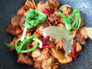 新疆大盘鸡,放小葱结、八角、香叶和干红辣椒炒香（如果能吃辣可以将干红辣椒掰开）。 
