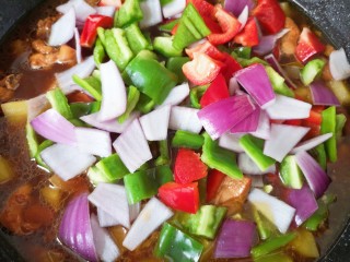 新疆大盘鸡,下入红彩椒、青椒和洋葱翻炒1-2分钟即可关火。 