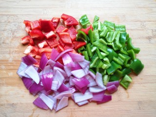 新疆大盘鸡,红彩椒、青椒和洋葱分别洗干净切成块。 