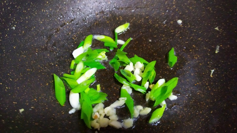 丝瓜炒蛋,锅中再加少许油，加入葱花和蒜末炒出香味。