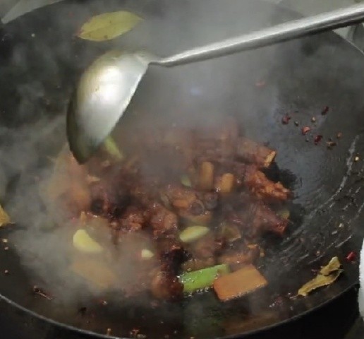 红烧羊排,色泽炒至均匀以后从锅中淋入料酒5克，因为料酒在加热的过程中挥发能减少羊排的腥味