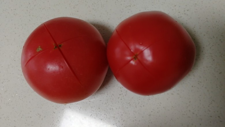 西紅柿香菇湯,西紅柿洗淨,頂部切花刀,開水燙一下去皮.