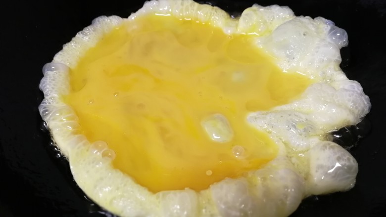 丝瓜炒蛋,油5成热倒入蛋液。