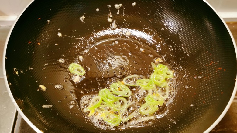 丝瓜炒蛋,锅中留下底油，继续加热，放入葱片炒出香味。