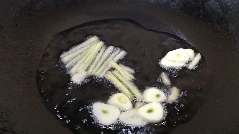 香菇肉片,热锅凉油，油微热放入姜丝和蒜片，文火炒香。