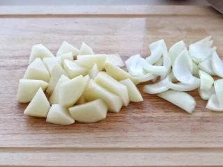 红烧牛腩,将土豆刮去外皮切滚刀块，洗净后放入清水中浸泡，防止氧化变色，洋葱随意的切成块状。