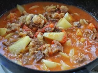 红烧牛腩,待西红柿完全融入汤汁里、土豆软熟时按照个人口味调入盐，改大火翻炒收汁。