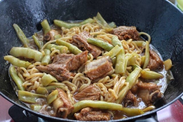 排骨豆角焖面,待面条焖熟后用筷子与锅中其他食材混合拌匀，使之裹上汤汁即可。