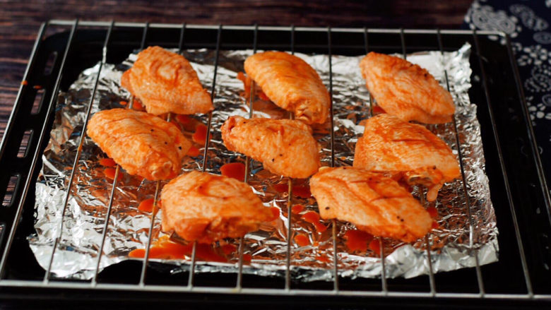奥尔良鸡翅,烤盘铺上锡纸，这样方便清洗，再放上烤网，从冰箱取出鸡翅，把鸡翅放在烤肉上