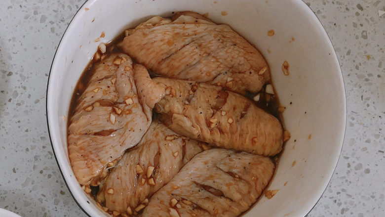 奥尔良鸡翅,奥尔良粉加清水混合，加入鸡翅和蒜末，腌制2小时。