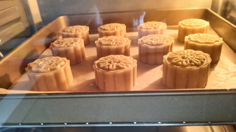 蛋黄莲蓉月饼,月饼表面喷上一层水，放入提前预热好的烤箱，中层190度烤5分钟