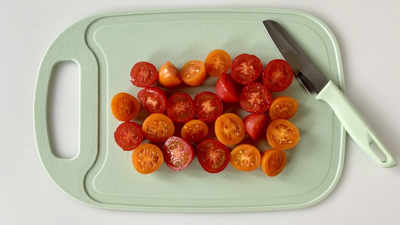 烤鸡胸肉蔬菜沙拉 ,把洗净的樱桃番茄对半切好。