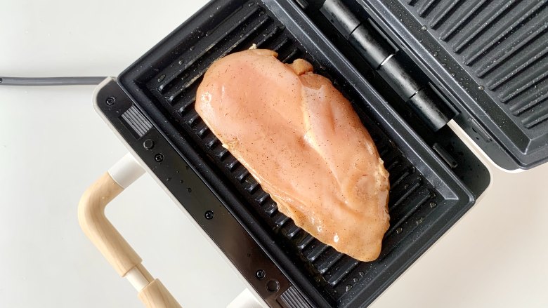 烤鸡胸肉蔬菜沙拉 ,油热后，把腌制好的鸡胸肉放入烤盘。